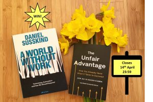 Two books lying on a wooden floor. Daniel Susskind's A World Without Work and The Unfair Advantage by Ash Ali and Hasan Kuba. There is also a bunch of daffodils. There are two signs, one saying Win! and one saying closes 14th April 23:59.